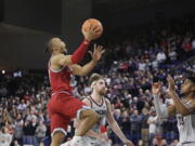 Loyola Marymount guard Cam Shelton, left, shoots the go-ahead basket in front of Gonzaga guard Malachi Smith, right, and forward Drew Timme during the second half of an NCAA college basketball game, Thursday, Jan. 19, 2023, in Spokane, Wash. Loyola Marymount won 68-67.