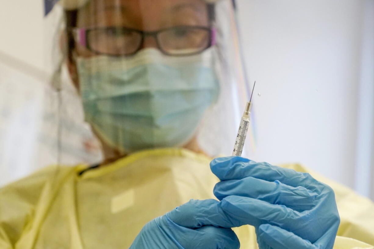 FILE - A physician assistant prepares a syringe with the Mpox vaccine for a patient at a vaccination clinic in New York on Friday, Aug. 19, 2022.  Mpox is no longer the exploding health crisis that it appeared to be less than six months ago. So who deserves the credit for controlling the U.S. outbreak?