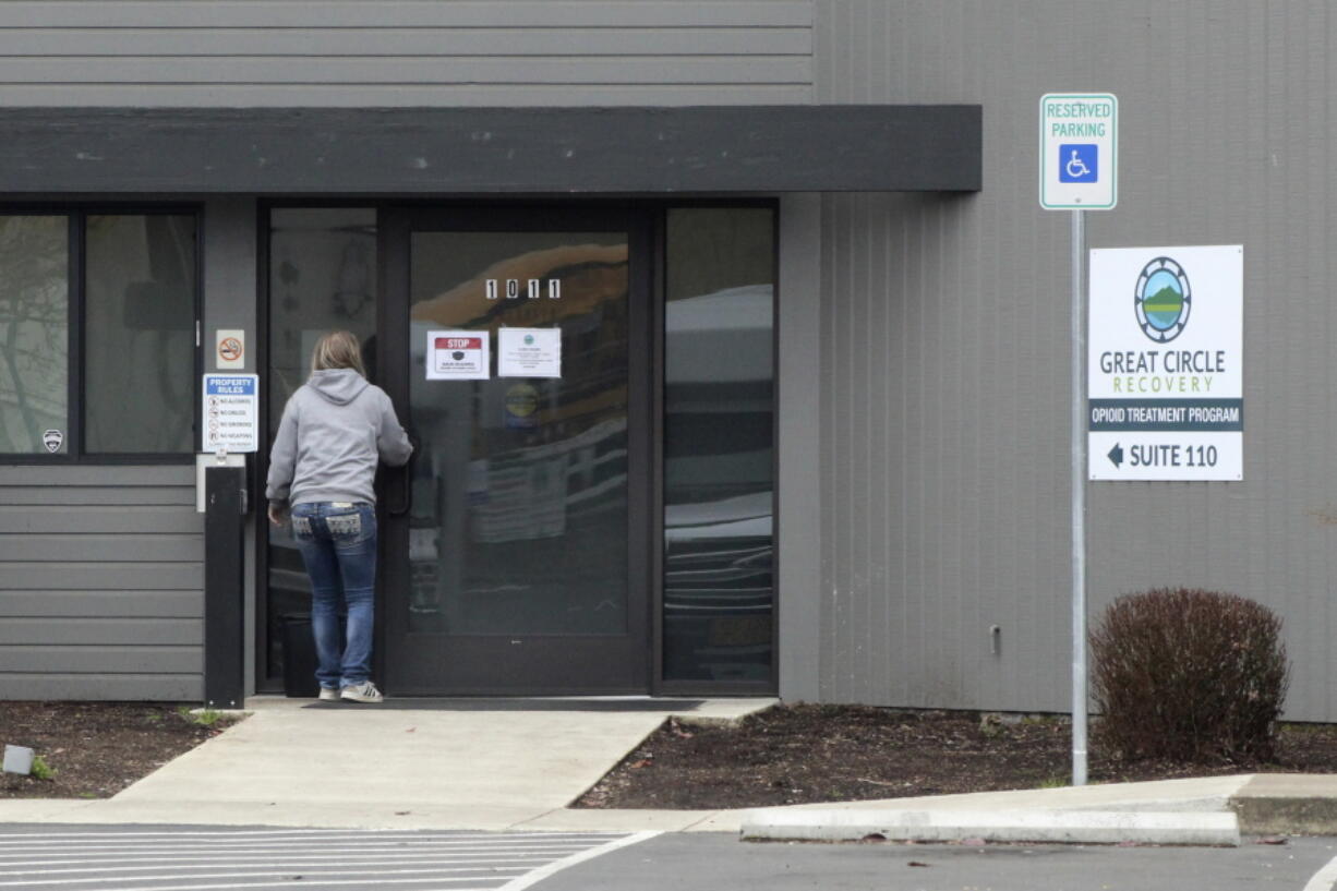 FILE - A woman enters the Great Circle drug treatment center in Salem, Ore., on March 8, 2022. Two years ago, Oregonians voted to decriminalize drugs and dedicate hundreds of millions of dollars to treatment services, but the state's first-in-the-nation drug decriminalization has had a rocky start. Secretary of State Shemia Fagan said on Thursday, Jan. 19, 2023, as she released an audit of the program that it's too early to call it a failure.