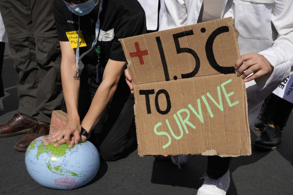 FILE - Demonstrators pretend to resuscitate the Earth while advocating for the 1.5 degree warming goal to survive at the COP27 U.N. Climate Summit, Nov. 16, 2022, in Sharm el-Sheikh, Egypt. A new study using artificial intelligence finds that the world will likely warm a few more tenths of a degrees within the next 10 to 12 years and breach a key climate change threshold aimed at limiting the worst effects of climate change.