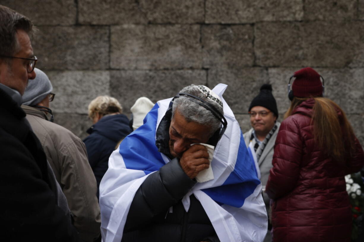 Zvika Karavany, 72, a Yemeni-born Israeli, wipes his tears in front of the Death Wall in the former Nazi German concentration and extermination camp Auschwitz during ceremonies marking the 78th anniversary of the liberation of the camp in Oswiecim, Poland, Friday, Jan. 27, 2023.