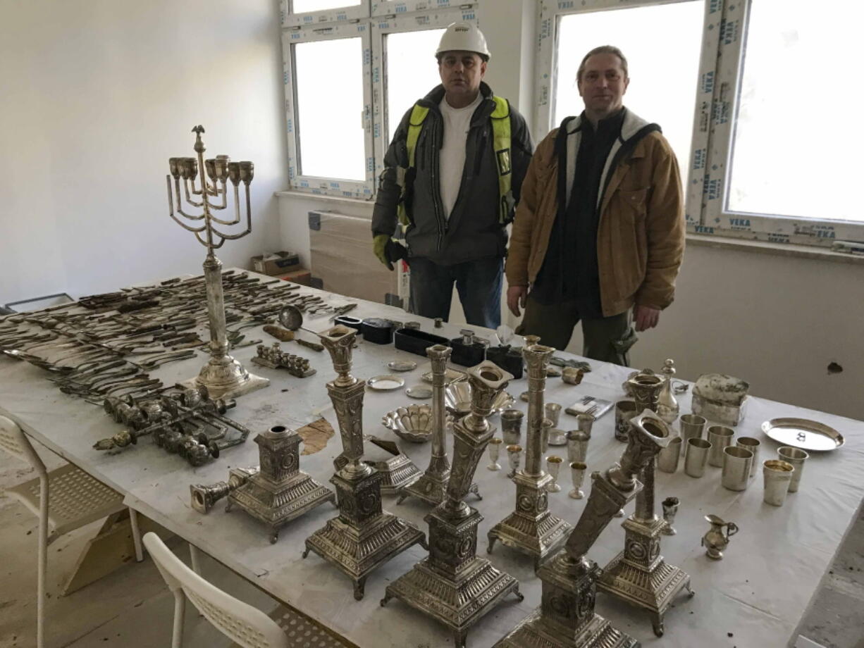 Krzysztof Hejmanowski, left, building inspector of the Warbud construction company and archaeologist Bartlomiej Gwozdz show objects that were most probably hidden by their Jewish owners during World War II on Wednesday in Lodz, Poland.