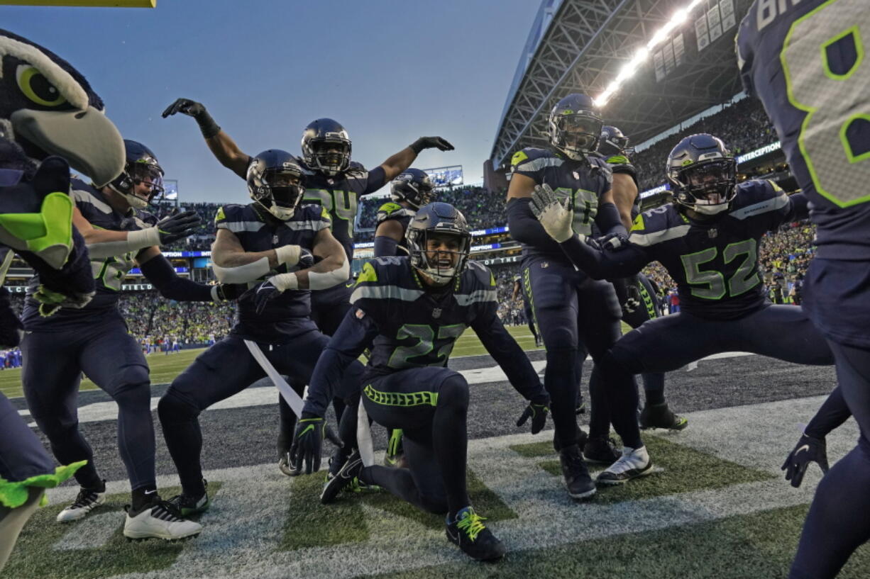 The Seattle Seahawks celebrate after an interception by safety Quandre Diggs during overtime of an NFL football game against the Los Angeles Rams Sunday, Jan. 8, 2023, in Seattle.