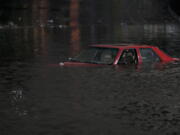 An empty vehicle is surrounded by floodwaters on a road in Oakland, Calif., Wednesday, Jan. 4, 2023. Another winter storm moved into California on Wednesday, walloping the northern part of the state with more rain and snow. It's the second major storm of the week in the parched state. (AP Photo/Godofredo A.