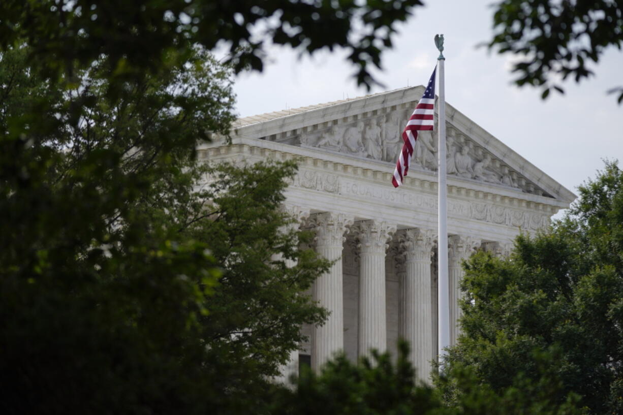 FILE - An American flag waves in front of the U.S. Supreme Court building in Washington, June 27, 2022. Supreme Court arguments are continuing long after a red light tells lawyers to stop. Arguments that usually lasted an hour have stretched beyond two this term so on many days it is well past lunchtime before the court breaks.