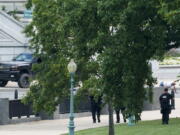 FILE - A man is apprehended after being in a pickup truck parked on the sidewalk in front of the Library of Congress' Thomas Jefferson Building, as seen from a window of the U.S. Capitol, Aug. 19, 2021, in Washington. A man who caused evacuations and an hourslong standoff with police on Capitol Hill when he claimed he had a bomb in his pickup truck outside the Library of Congress pleaded guilty on Friday, Jan. 27, 2023, to a charge of threatening to use an explosive. Floyd Ray Roseberry faces up to 10 years behind bars and is scheduled to be sentenced in June.