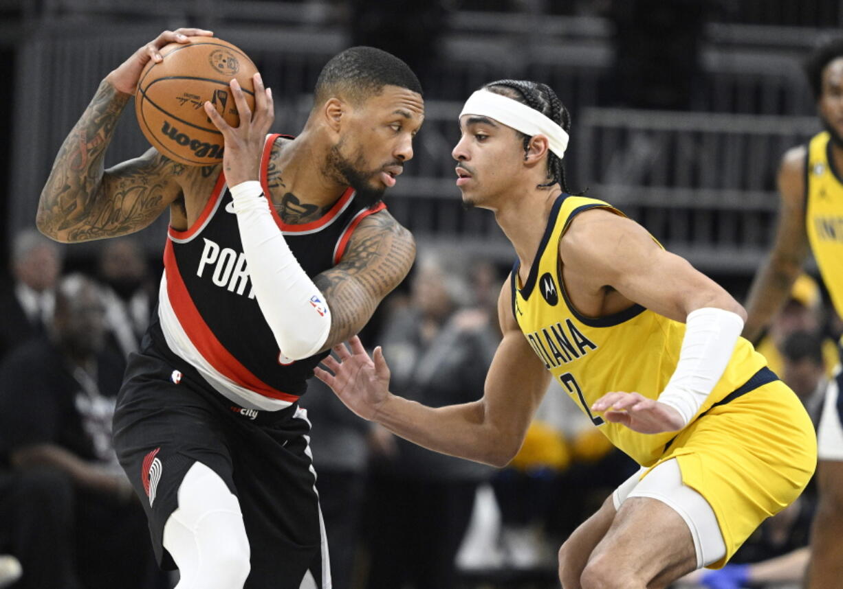 Portland Trail Blazers guard Damian Lillard, left, keeps the ball away from Indiana Pacers guard Andrew Nembhard (2) during the second quarter of an NBA basketball game, Friday, Jan. 6, 2023, in Indianapolis.