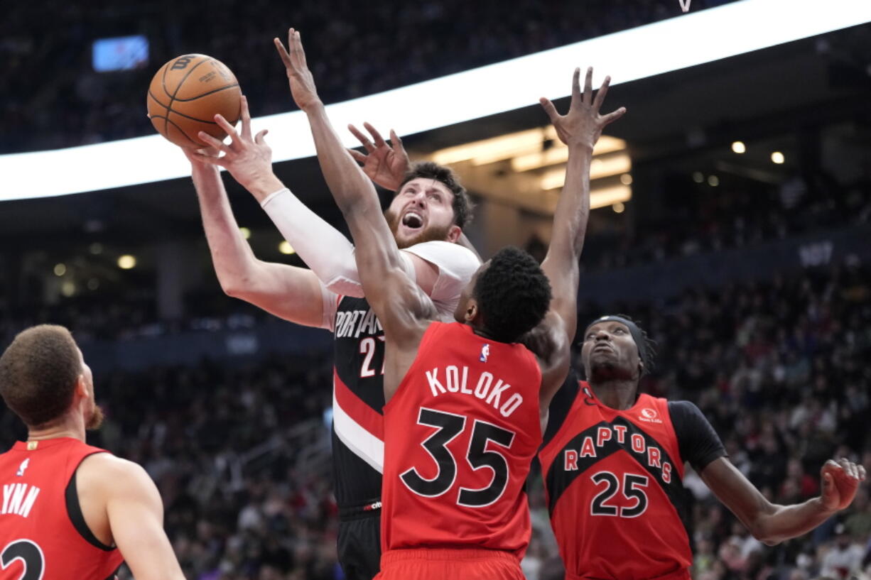 Portland Trail Blazers guard Damian Lillard, right, dribbles as Toronto Raptors forward Scottie Barnes, left, defends during first-half NBA basketball game action in Toronto, Sunday, Jan. 8, 2023.