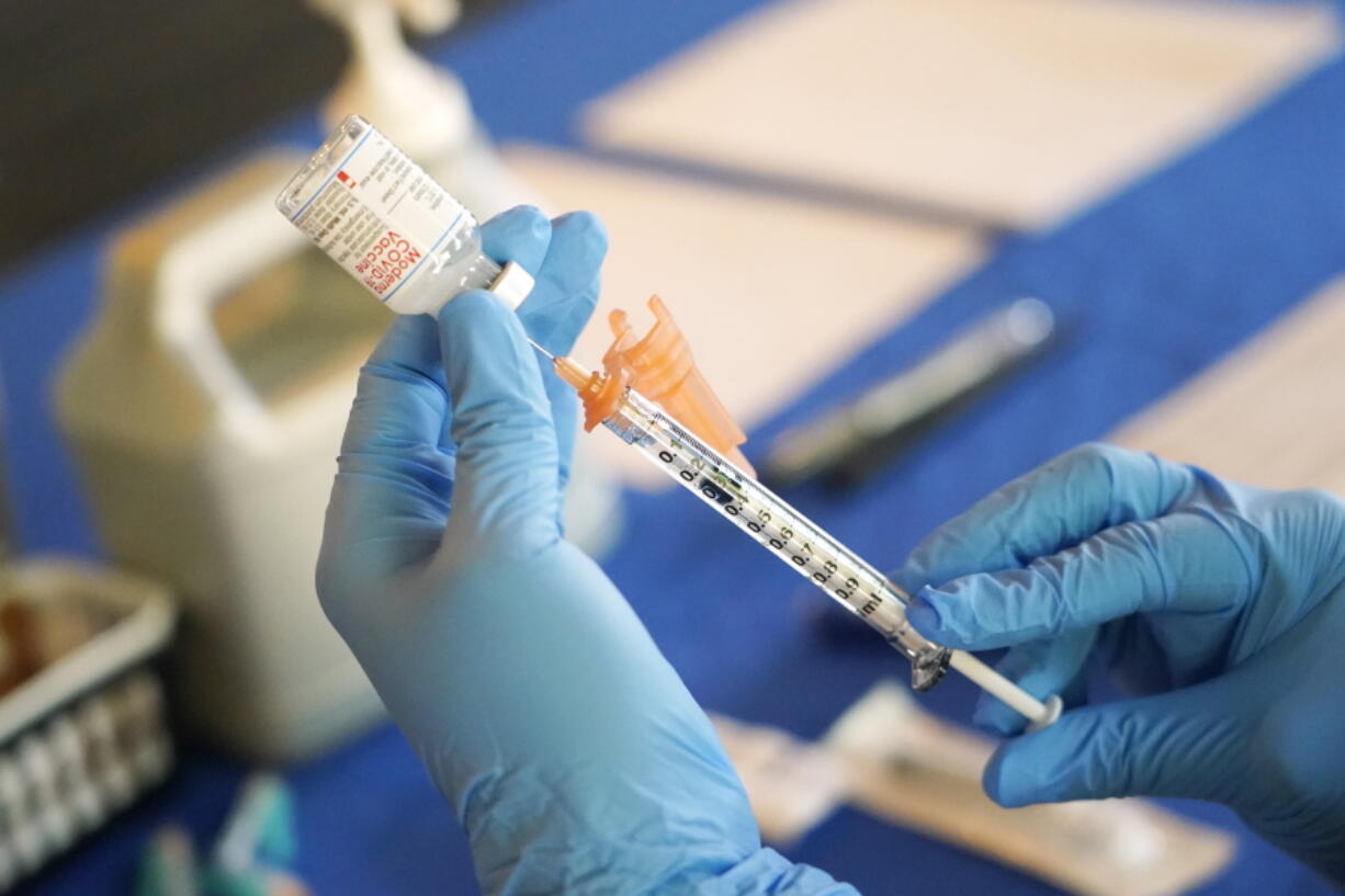 FILE - A nurse prepares a syringe of a COVID-19 vaccine at an inoculation station in Jackson, Miss., July 19, 2022. U.S. health officials are proposing a simplified approach to COVID-19 vaccinations, which would allow most adults and children to get a once-a-year shot to protect against the mutating virus. The new system unveiled Monday, Jan. 23, 2023 would make COVID-19 inoculations more like the annual flu shot. Americans would no longer have to keep track of how many shots they've received or how many months it's been since their last booster. (AP Photo/Rogelio V.