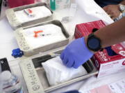 Syringes with vaccines are prepared at the L.A. Care and Blue Shield of California Promise Health Plans' Community Resource Center where they were offering members and the public free flu and COVID-19 vaccines Friday, Oct. 28, 2022, in Lynwood, Calif. The U.S. is poised to make COVID-19 vaccinations more like a yearly flu shot, a major shift in strategy despite a long list of questions about how to best protect against a still rapidly mutating virus.