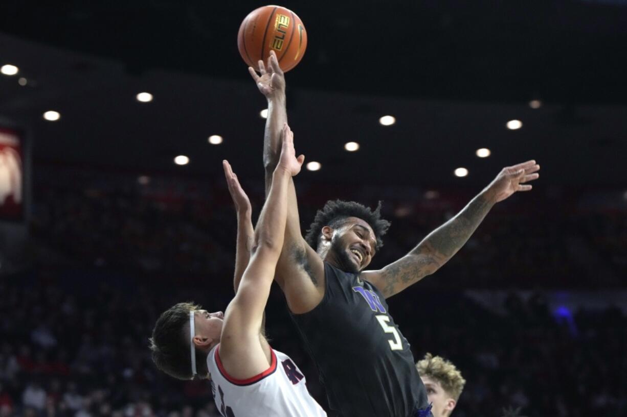 Arizona guard Kerr Kriisa fouls Washington guard Jamal Bey (5) during the first half of an NCAA college basketball game Thursday, Jan. 5, 2023, in Tucson, Ariz.