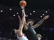 Arizona guard Kerr Kriisa fouls Washington guard Jamal Bey (5) during the first half of an NCAA college basketball game Thursday, Jan. 5, 2023, in Tucson, Ariz.