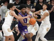 Washington forward Keion Brooks, second from left, picks up a loose ball as, from left, Colorado guard J'Vonne Hadley, forward Tristan da Silva and guard Nique Clifford defend in the second half of an NCAA college basketball game Thursday, Jan. 19, 2023, in Boulder, Colo.