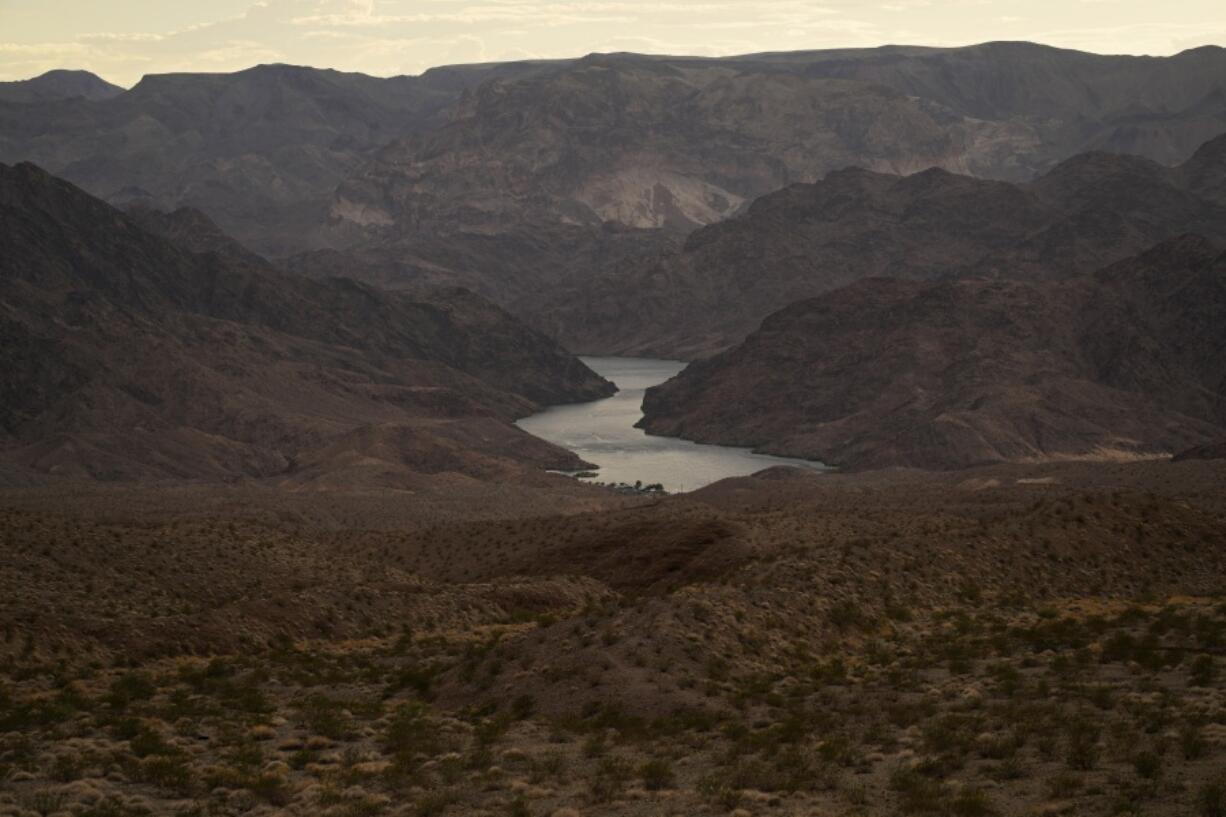 FILE - Water flows down the Colorado River downriver from Hoover Dam in northwest Arizona, on Aug. 14, 2022, near the Lake Mead National Recreation Area. More than 10% of the water carried by the Colorado River evaporates, leaks or spills as the 1,450-mile powerhouse river of the West flows through the region's dams, reservoirs and open-air canals.