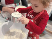 Lindsay Gardner and her 3-year-old daughter,  Ellie, measure flour into a mixing bowl for cookies.