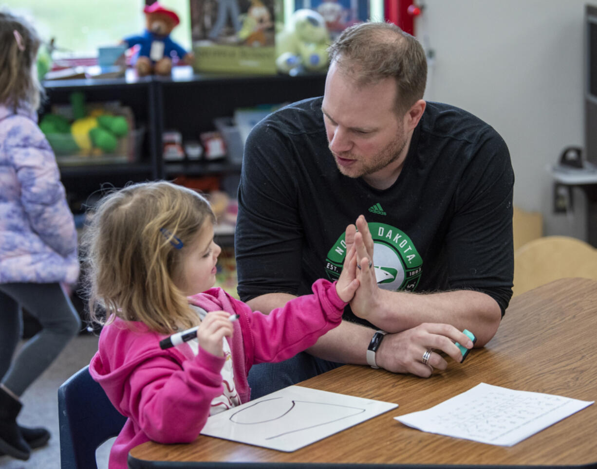 Transitional kindergarten teacher Shawn Sears high fives student Claire Lindelien on Tuesday during class at Hockinson Heights Elementary School. Transitional kindergarten programs provide a year of pre-K style learning for students who missed the age cutoff for kindergarten and have limited access to early learning options.