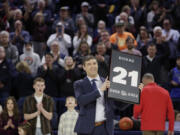 Former Gonzaga and NBA basketball player Dan Dickau holds a framed Gonzaga jersey number during his jersey retirement ceremony before an NCAA college basketball game between Gonzaga and San Francisco, Thursday, Feb. 9, 2023, in Spokane, Wash.