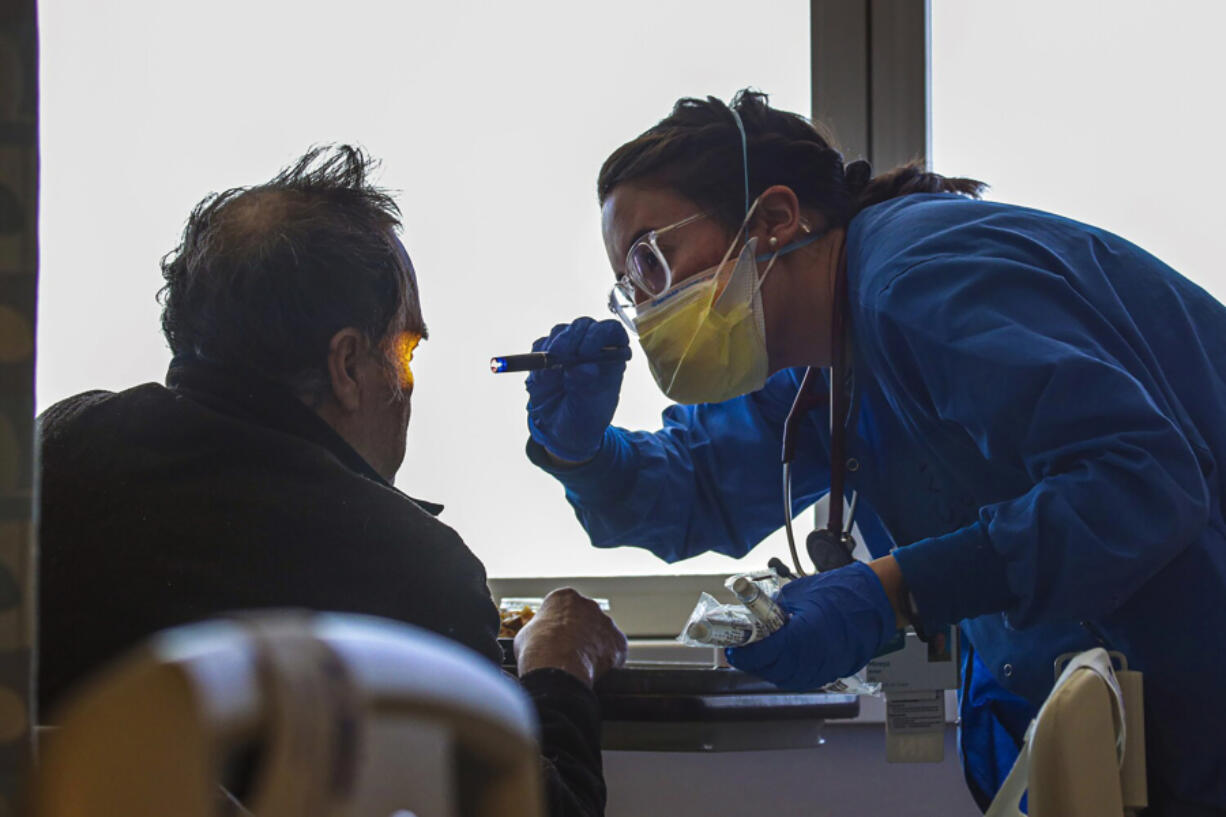 A nurse, right, attends to a non-COVID patient at Emanate Health Queen of the Valley Hospital on Feb. 8, 2022, in West Covina, Calif.