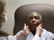 Nurse practitioner Rachel Roberts examines Stephanie Walker of Tarboro, N.C., during an appointment Feb. 2 at the Duke Cancer Clinic in Durham, N.C. For the last six years, Walker has endured painful monthly injections to help treat her cancer.