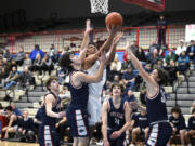 Ridgefield’s Sid Bryant puts up a shot in between multiple Black Hills defenders on Thursday, Feb.