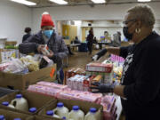 At Chosen Tabernacle Ministries pantry in Chicago, Johanna Lezama, left, chooses food with the help of Angela Bailey-Lane on Feb.