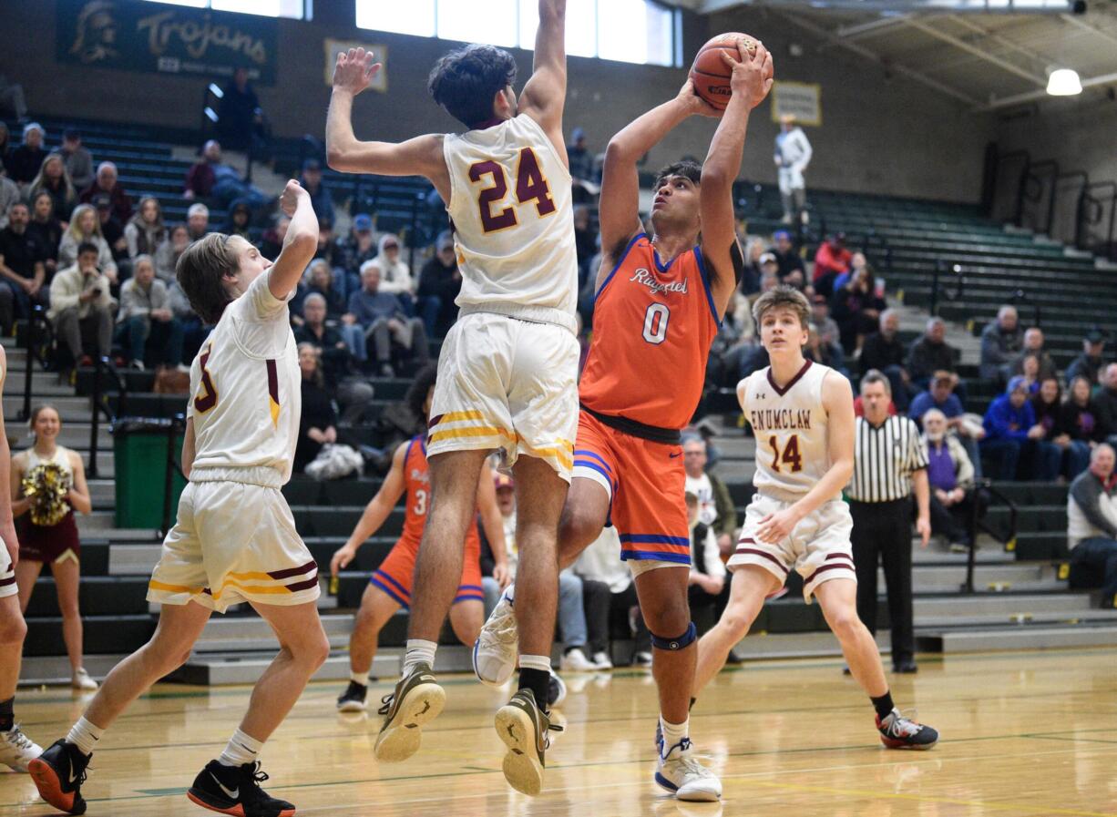 Ridgefield's Sid Bryant (0) gets ready to release a jump shot while falling away against Enumclaw's Austin Pierce (24) in a Class 2A state opening round game on Saturday, Feb. 25, 2023, at Auburn High School.