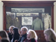 Framed photos and maps of Fort Vancouver sit behind crowd members Wednesday at the Armed Forces Reserve Center in Vancouver.