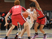 Union senior Yanni Fassilis, center, drives between two Camas defenders Friday, Feb. 3, 2023, during the first half of a game between Camas and Union at Union High School.