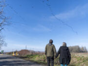 Hector Hinojosa, left, and his wife, Jodell Hinojosa, watch a flock of geese fly over La Frambois Road on Wednesday near the site of a proposed megawarehouse in the Fruit Valley neighborhood. He is among those who are outspoken against the development, arguing that it will only lead to an increase in air pollution and disruption of natural habitats and farmland.