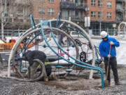 CME Play workers pour concrete around the supports of a free-form climbing structure that is part of a new playground Tuesday at Esther Short Park.