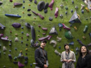 From left: Hanz Kroesen, co-owner of Source Climbing Center, looks up at the climbing wall with U.S. Rep. Marie Gluesenkamp Perez, D-Skamania, and Isabel Guzman, head of the Small Business Administration, during a tour Friday morning.