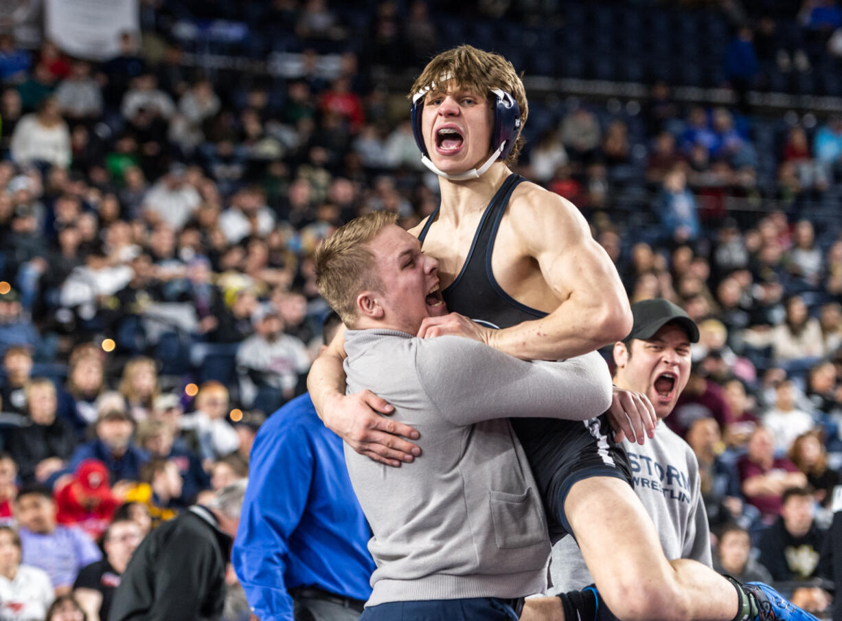 Skyview’s JJ Schoenlein, 170 pounds, leaps into his coach’s arms after winning the championship at Mat Classic XXXIV on Saturday, February 18, 2023, at the Tacoma Dome.