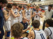 King's Way head boys basketball coach Daven Harmeling, center, talks to the team between quarters Saturday, Feb. 25, 2023, during the Knights’ 59-44 win against La Salle at Battle Ground High School.