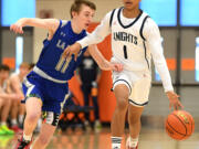 King’s Way junior Jaydon Hall, right, keeps the ball away from La Salle sophomore Jaxton Caffrey on Saturday, Feb. 25, 2023, during the Knights’ 59-44 win against La Salle at Battle Ground High School.