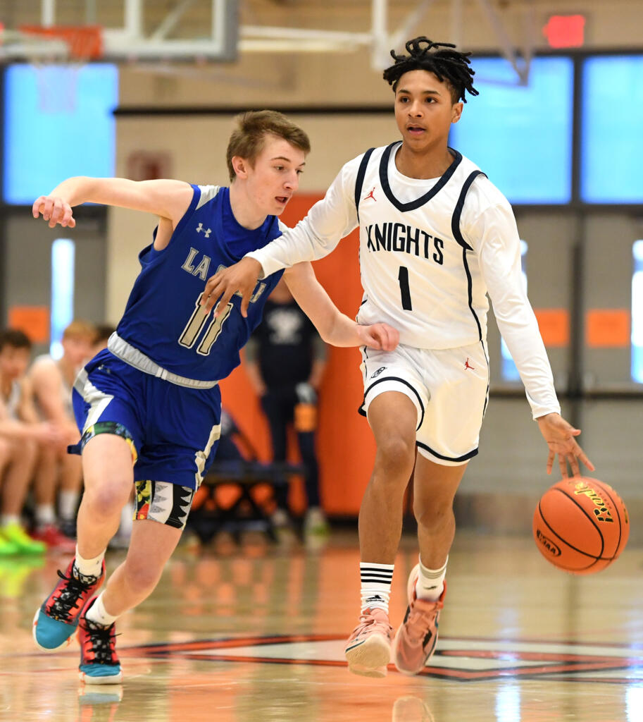 King’s Way junior Jaydon Hall, right, keeps the ball away from La Salle sophomore Jaxton Caffrey on Saturday, Feb. 25, 2023, during the Knights’ 59-44 win against La Salle at Battle Ground High School.