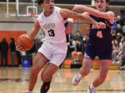 Union senior Yanni Fassilis, left, drives to the basket under pressure from Sumner sophomore Jaylen Hyppa on Saturday, Feb. 25, 2023, during the Titans’ 67-40 at Battle Ground High School.