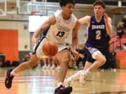 Union senior Yanni Fassilis, center, dribbles the ball under pressure from Sumner junior Luke Bohl on Saturday, Feb. 25, 2023, during the Titans’ 67-40 at Battle Ground High School.