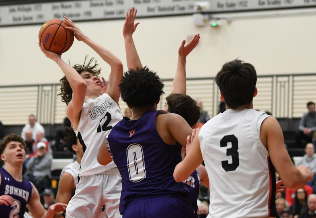 Union's Kody Holcomb, left, shoots the ball Saturday, Feb. 25, 2023, during the Titans’ 67-40 at Battle Ground High School.