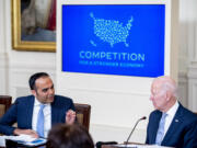 Consumer Financial Protection Bureau director Rohit Chopra, left, accompanied by President Joe Biden, right, speaks at a meeting with his Competition Council on the economy and prices in the East Room of the White House in Washington, Wednesday, Feb. 1, 2023.