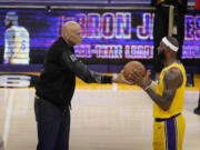 Kareem Abdul-Jabbar, left, hands the ball to Los Angeles Lakers forward LeBron James after passing Abdul-Jabbar to become the NBA's all-time leading scorer during the second half of an NBA basketball game against the Oklahoma City Thunder Tuesday, Feb. 7, 2023, in Los Angeles.