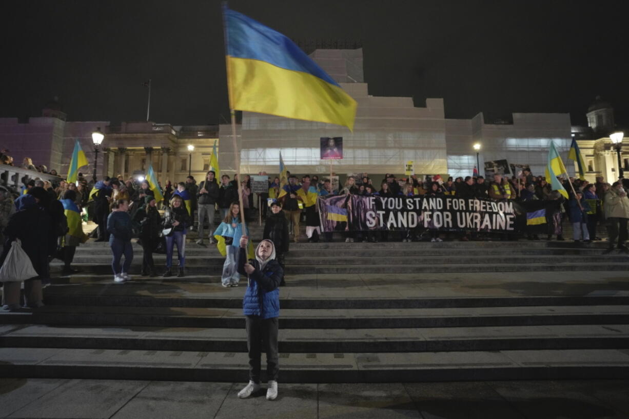 People attend a vigil at the Trafalgar Square organised by the Ukrainian and US Embassy, ahead of the one-year anniversary of the invasion of Ukraine, in London, Thursday, Feb. 23, 2023.