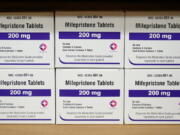 FILE - Boxes of the drug mifepristone sit on a shelf at the West Alabama Women's Center in Tuscaloosa, Ala., on March 16, 2022. Attorney generals in 20 conservative-led states warned CVS and Walgreens on Wednesday, Feb. 1, 2023, that they could face legal consequences if they sell abortion pills by mail in those states. (AP Photo/Allen G.