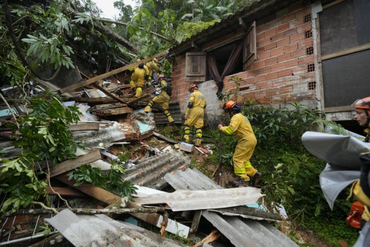 Rescue workers search for survivors after flooding triggered deadly landslides near Juquehy beach in Sao Sebastiao, Brazil, Monday, Feb. 20, 2023.