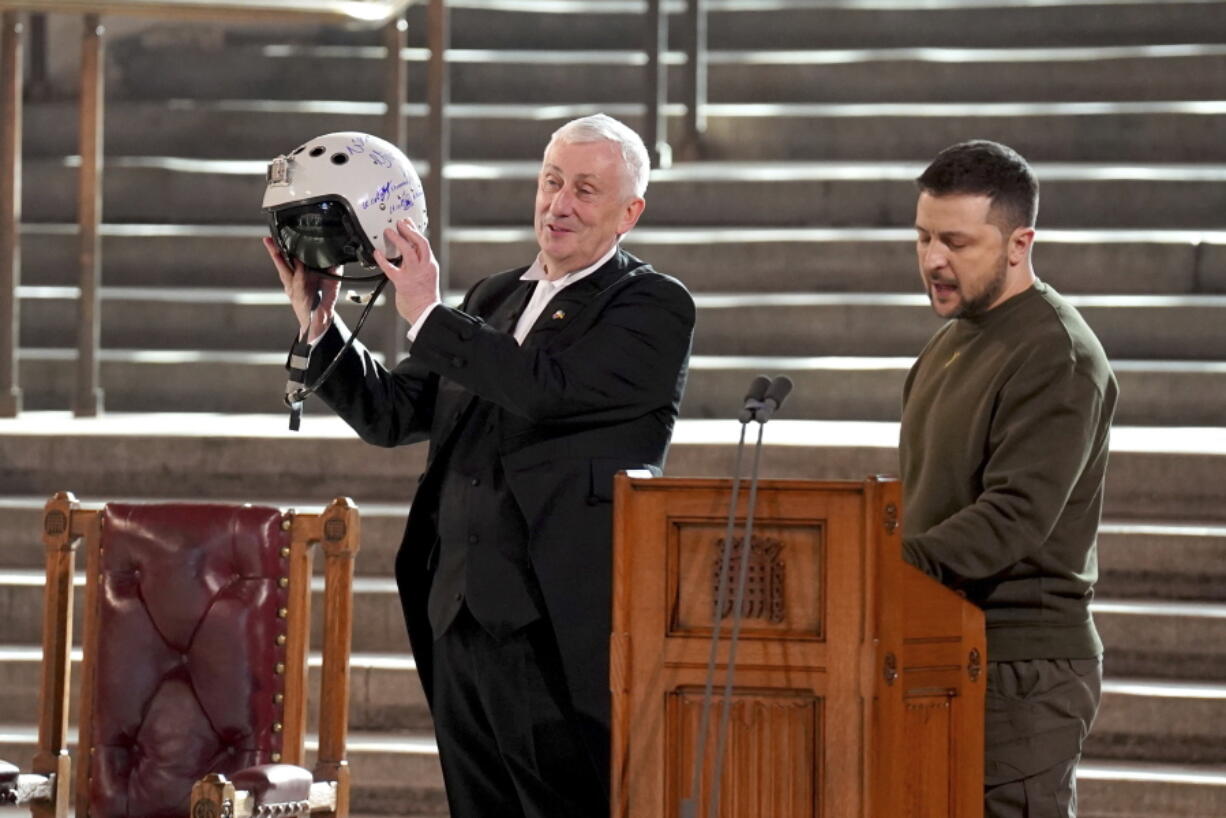 Speaker of the House of Commons, Sir Lindsay Hoyle, left, holds the helmet of one of the most successful Ukrainian pilots, inscribed with the words "We have freedom, give us wings to protect it", which was presented to him by Ukrainian President Volodymyr Zelenskyy as he addressed parliamentarians in Westminster Hall, London,, during his first visit to the UK since the Russian invasion of Ukraine, Wednesday Feb. 8, 2023.