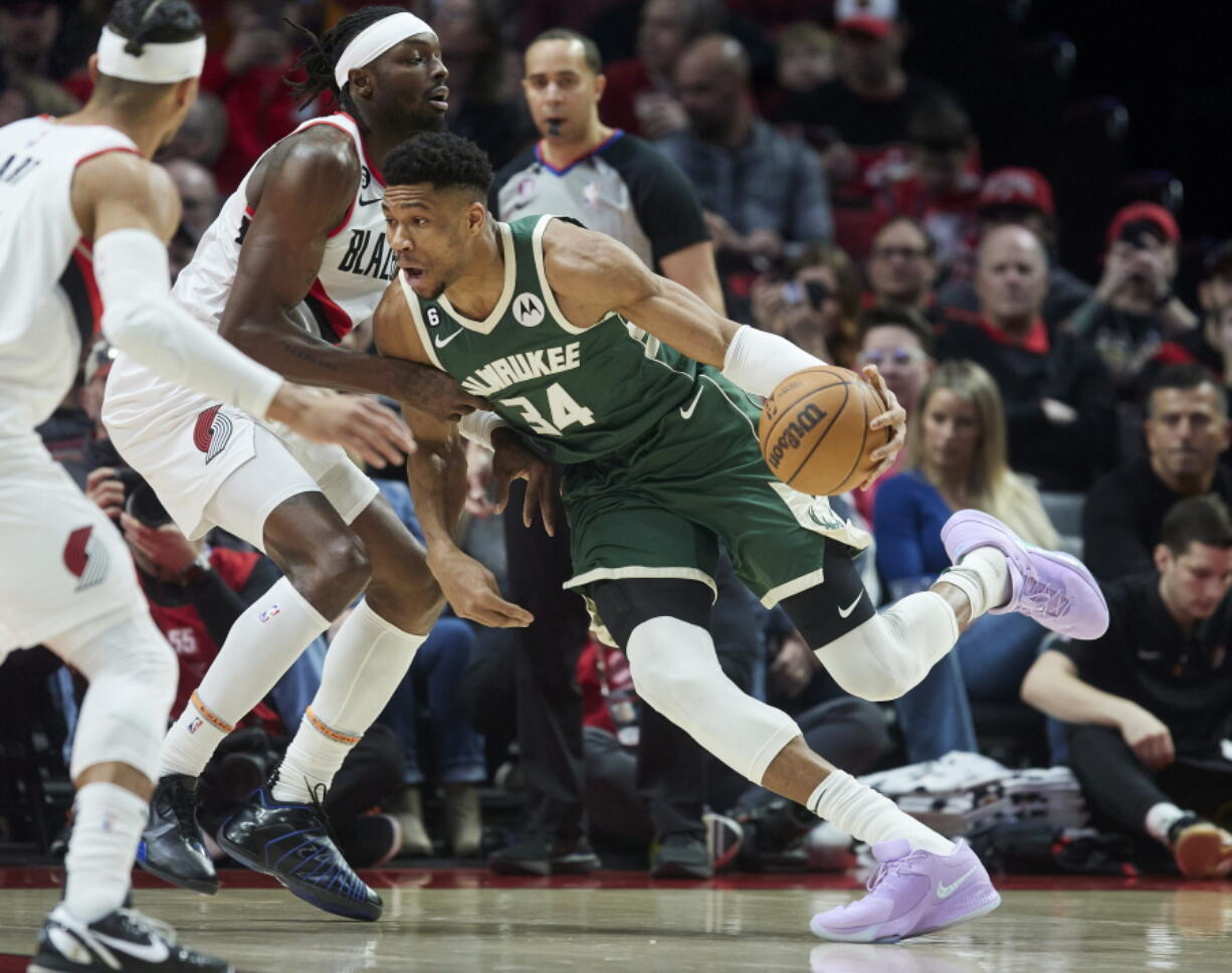 Milwaukee Bucks forward Giannis Antetokounmpo, right, drives to the basket toward Portland Trail Blazers forward Jerami Grant during the first half of an NBA basketball game in Portland, Ore., Monday, Feb. 6, 2023.