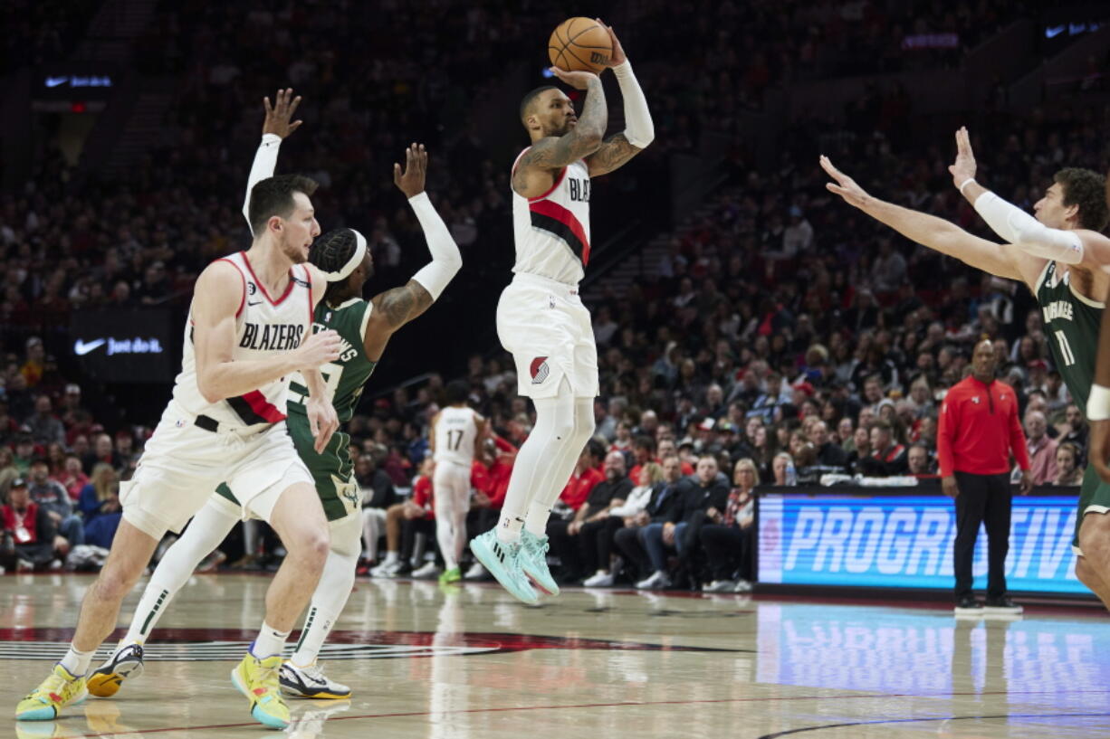 Portland Trail Blazers guard Damian Lillard, center, shoots a 3-point basket over Milwaukee Bucks guard Wesley Matthews, left, and center Brook Lopez during the first half of an NBA basketball game in Portland, Ore., Monday, Feb. 6, 2023.