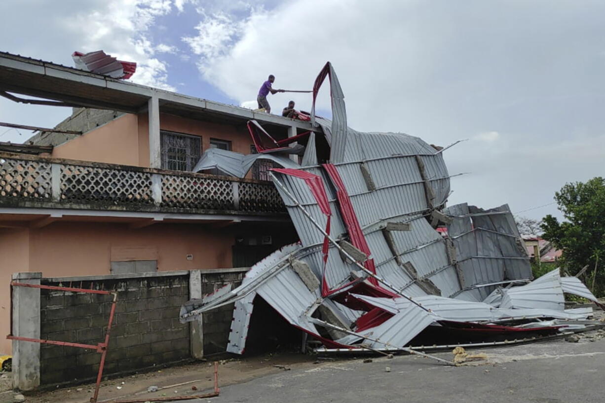 People work on a damaged building, in Mananjary district, Madagascar, Wednesday Feb. 22, 2023 after cyclone Freddy reached Madagascar. A slightly weakened Cyclone Freddy has made landfall in Madagascar, where schools, businesses and public transportation were shut down ahead of its arrival. Freddy was packing winds gusting to 180 kilometers per hour, or about 111 miles per hour, as it came ashore in a nation already hit in January by a tropical storm that killed at least 30 people.