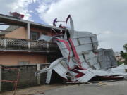 People work on a damaged building, in Mananjary district, Madagascar, Wednesday Feb. 22, 2023 after cyclone Freddy reached Madagascar. A slightly weakened Cyclone Freddy has made landfall in Madagascar, where schools, businesses and public transportation were shut down ahead of its arrival. Freddy was packing winds gusting to 180 kilometers per hour, or about 111 miles per hour, as it came ashore in a nation already hit in January by a tropical storm that killed at least 30 people.