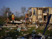 FILE - Aiden Locobon, left, and Rogelio Paredes look through the remnants of their family's home destroyed by Hurricane Ida, Sept. 4, 2021, in Dulac, La. A new study says that back-to-back hurricanes that hit the same general place in the United States seem to be happening more often.