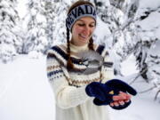 This photo provided by the University of Nevada, Reno shows University of Nevada, Reno student Michelle Werdann feeds a wild Mountain Chickadee pine nuts at Chickadee Ridge in Mount Rose Meadows, Nevada, Friday, Jan.